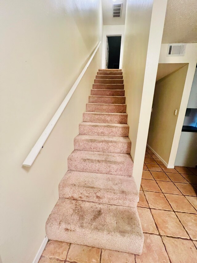 stairs with tile patterned floors