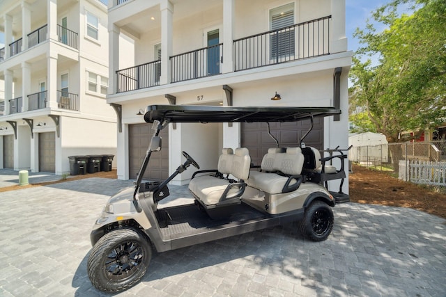 exterior space featuring a garage, decorative driveway, and fence