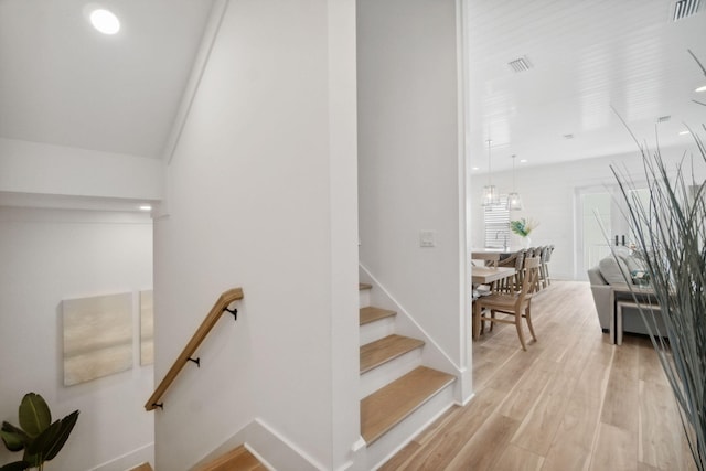 stairs featuring hardwood / wood-style flooring and vaulted ceiling