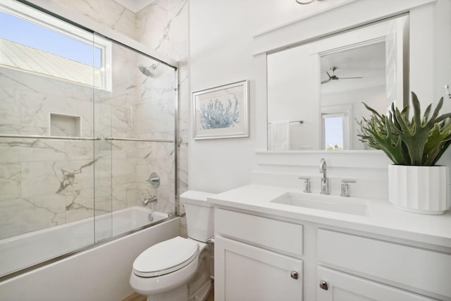 full bathroom featuring toilet, ceiling fan, bath / shower combo with glass door, and vanity