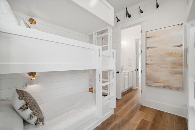 bedroom with light hardwood / wood-style flooring and connected bathroom