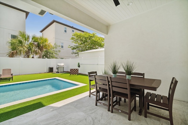 view of swimming pool with a fenced in pool, outdoor dining area, a patio, a lawn, and a fenced backyard