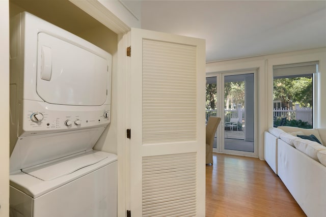 washroom featuring light hardwood / wood-style flooring and stacked washer / drying machine