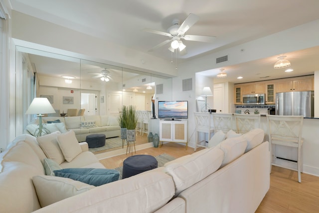 living room featuring light wood-type flooring and ceiling fan