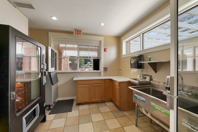 kitchen featuring light tile patterned floors, sink, and black refrigerator