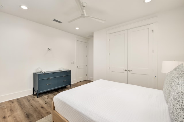 bedroom with ceiling fan, a closet, and dark hardwood / wood-style flooring