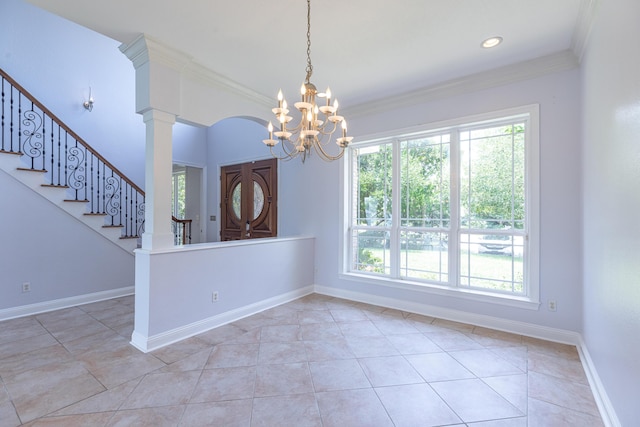 unfurnished dining area with a chandelier, light tile patterned floors, ornate columns, and crown molding