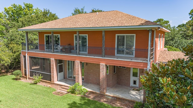 back of property featuring a balcony, a yard, and a patio