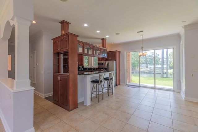 kitchen with a kitchen breakfast bar, light tile patterned flooring, crown molding, and decorative columns