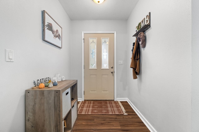 doorway to outside with a textured ceiling and dark wood-type flooring