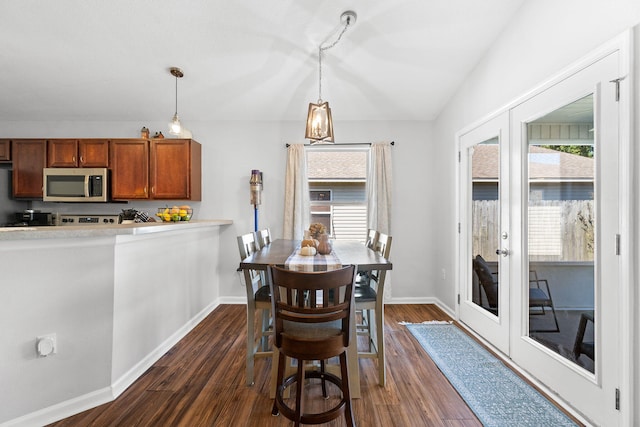 dining area featuring lofted ceiling and dark hardwood / wood-style floors