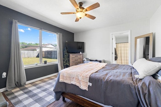 bedroom featuring ensuite bath, ceiling fan, and dark wood-type flooring