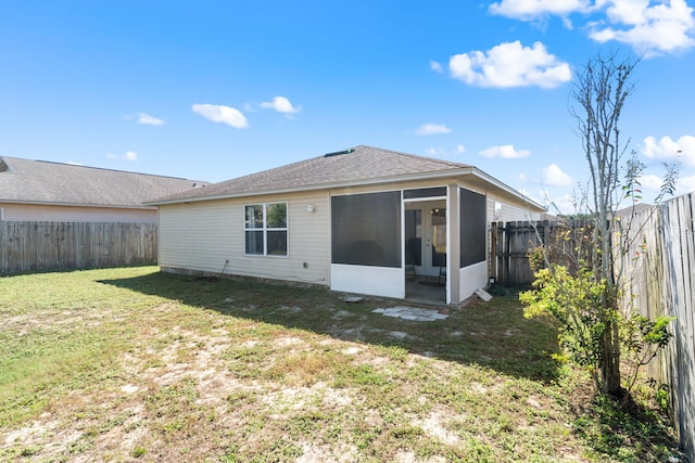 rear view of property with a sunroom and a lawn