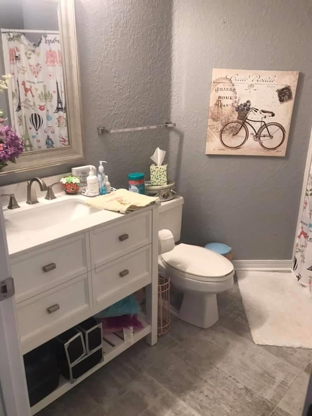 bathroom featuring toilet, vanity, and wood-type flooring