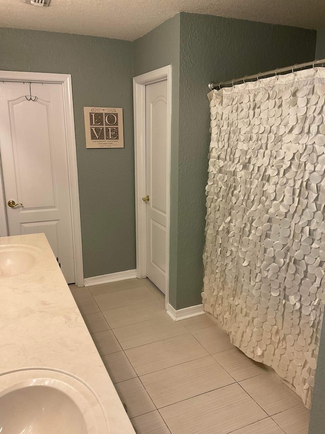 bathroom with vanity, tile patterned flooring, a textured ceiling, and a shower with shower curtain