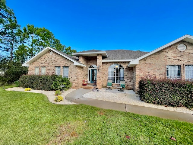 view of front facade featuring a front lawn and a patio