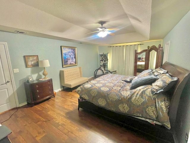 bedroom featuring ceiling fan, a textured ceiling, lofted ceiling, and wood-type flooring