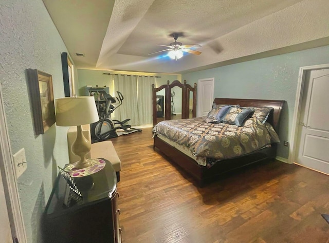 bedroom with hardwood / wood-style floors, a textured ceiling, and ceiling fan