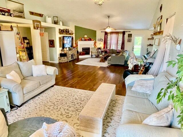 living room featuring wood-type flooring, lofted ceiling, and ceiling fan