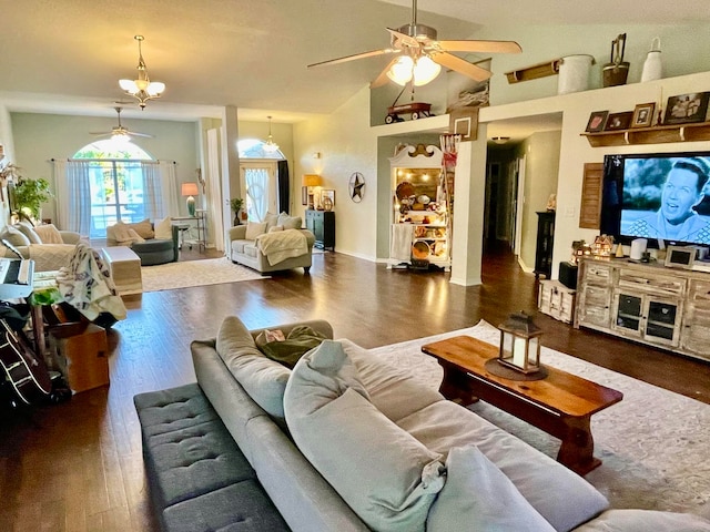 living room with ceiling fan with notable chandelier, dark hardwood / wood-style flooring, and high vaulted ceiling