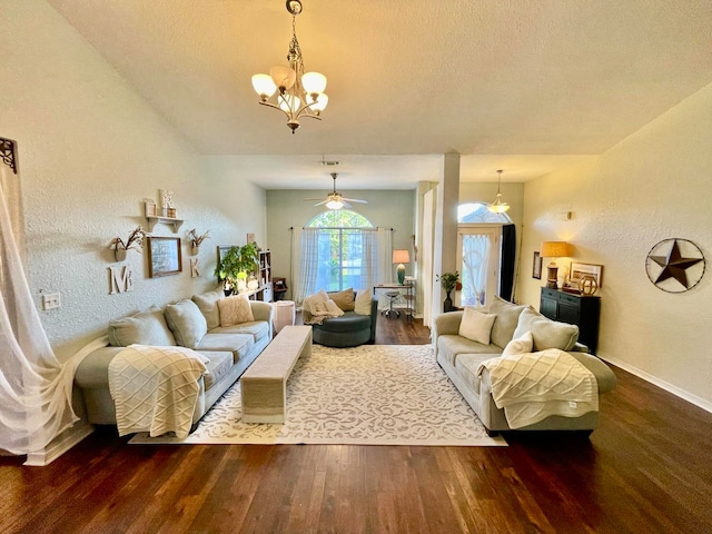 living room with ceiling fan with notable chandelier, hardwood / wood-style flooring, and a textured ceiling