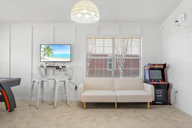 living area featuring lofted ceiling and an inviting chandelier