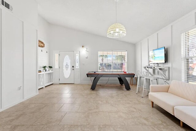 tiled entryway featuring plenty of natural light and vaulted ceiling