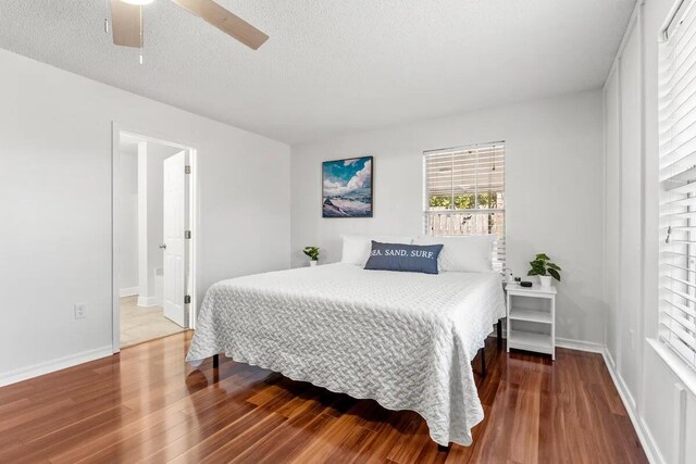 bedroom with ensuite bath, hardwood / wood-style floors, a textured ceiling, and ceiling fan