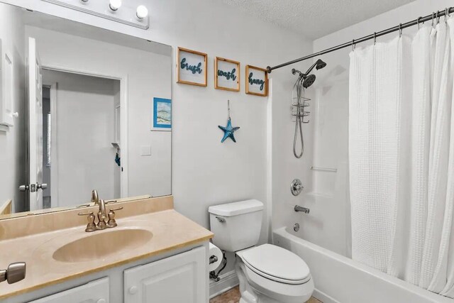 full bathroom with shower / bath combination with curtain, vanity, toilet, and a textured ceiling