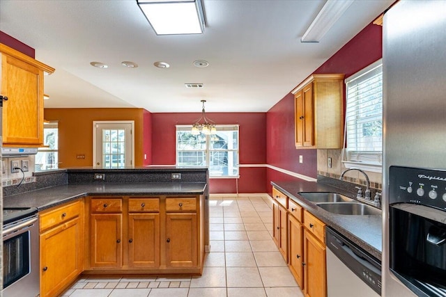 3968 Hickory St, Niceville, FL 32578 - kitchen with a sink, appliances with stainless steel finishes, dark countertops, and a peninsula