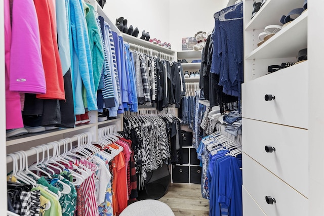 walk in closet with light hardwood / wood-style floors