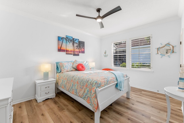 bedroom featuring light wood-style floors, a ceiling fan, baseboards, and crown molding