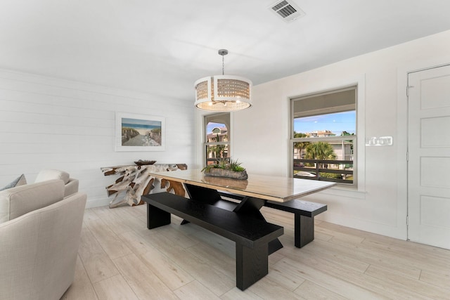 dining space with a chandelier and light hardwood / wood-style floors