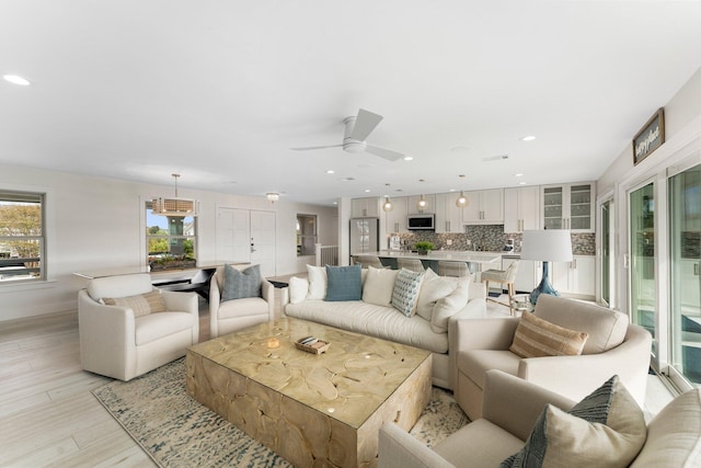 living room featuring light hardwood / wood-style flooring and ceiling fan