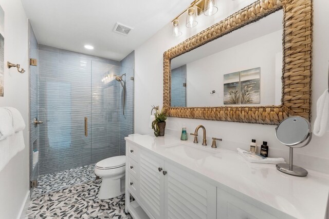 bathroom with vanity, tile patterned flooring, toilet, and an enclosed shower