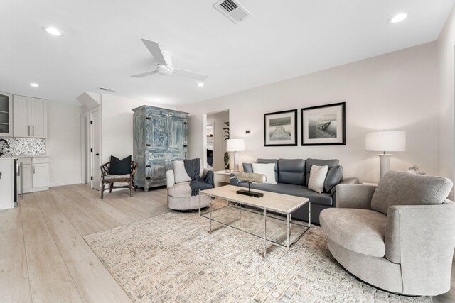 living room featuring light hardwood / wood-style floors and ceiling fan