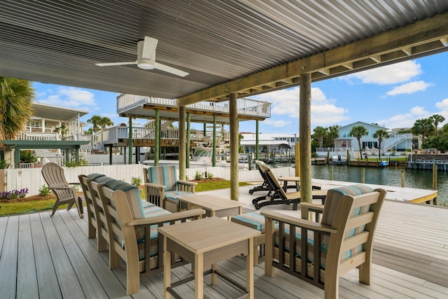 wooden terrace featuring ceiling fan, a boat dock, and a water view