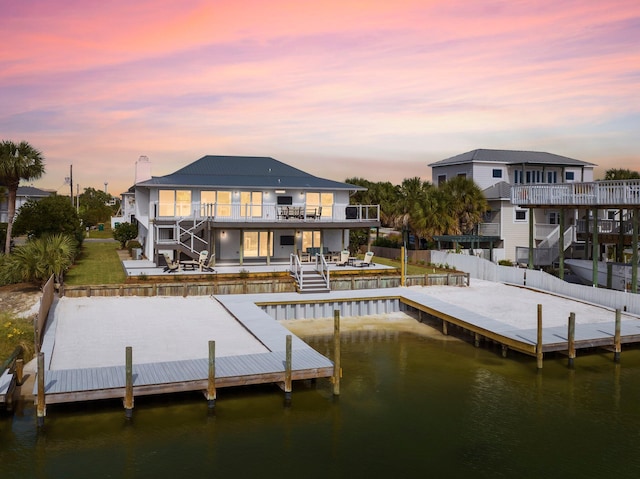 view of dock with a balcony, a water view, and a patio area