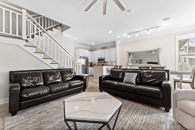 living room with crown molding and ceiling fan