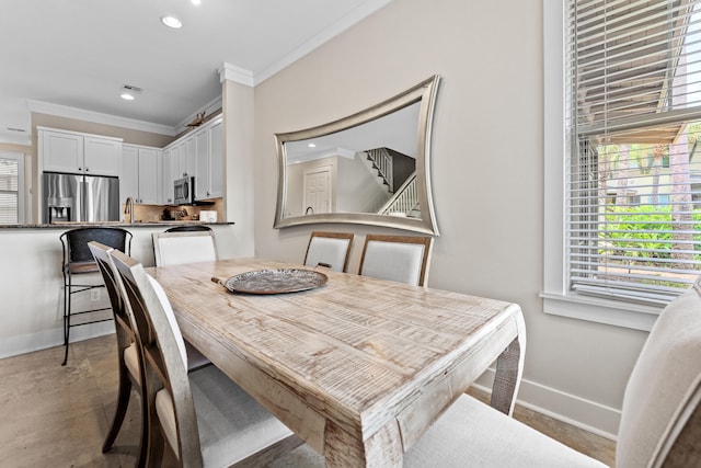 dining space featuring crown molding