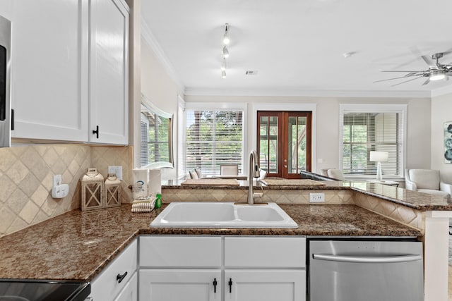 kitchen with kitchen peninsula, sink, a wealth of natural light, and white cabinetry