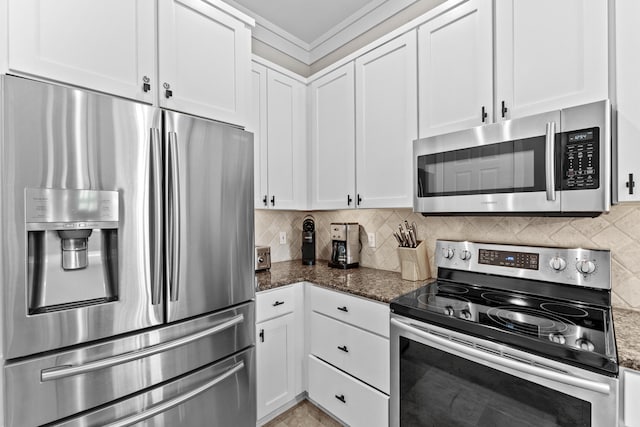 kitchen with dark stone countertops, stainless steel appliances, backsplash, and white cabinetry