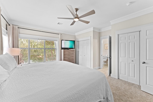 bedroom with two closets, light carpet, crown molding, and ceiling fan