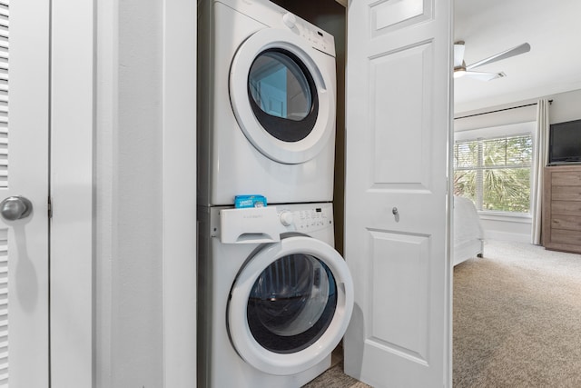 laundry area featuring stacked washer and dryer and carpet flooring