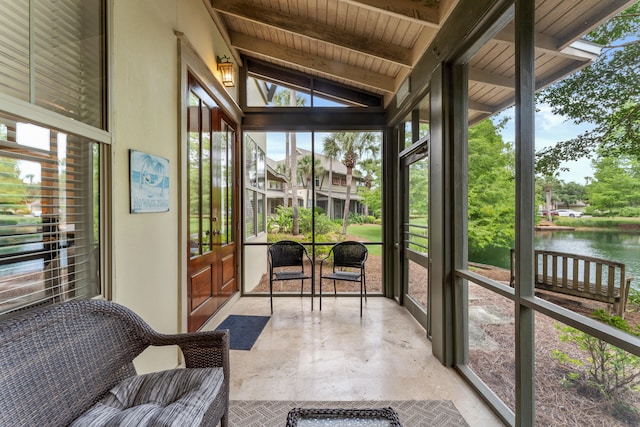 sunroom featuring wood ceiling, plenty of natural light, a water view, and lofted ceiling with beams