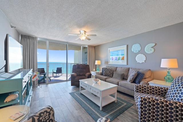 living room featuring floor to ceiling windows, ceiling fan, a textured ceiling, and dark hardwood / wood-style flooring