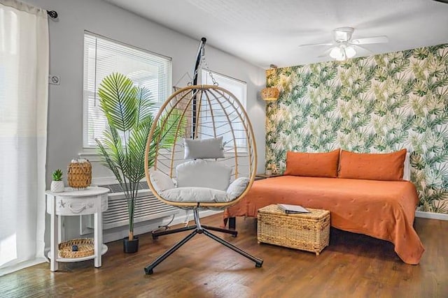 sitting room with ceiling fan and wood-type flooring