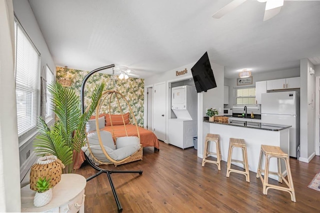 kitchen with ceiling fan, dark hardwood / wood-style flooring, kitchen peninsula, white cabinets, and white fridge