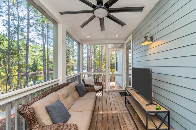 sunroom / solarium with wooden ceiling, a water view, and ceiling fan