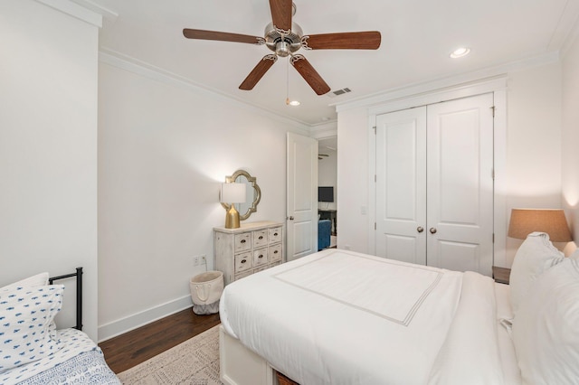 bedroom with dark hardwood / wood-style flooring, a closet, ornamental molding, and ceiling fan